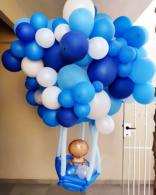 Globo aerostático hecho con globos color celestes, azules y blancos. Globo forma bebé dentro del aerostático.