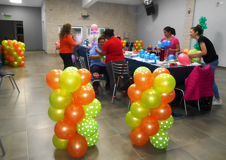 Alumnas realizando arco en globos color amarillo, naranja y verde con puntos blancos