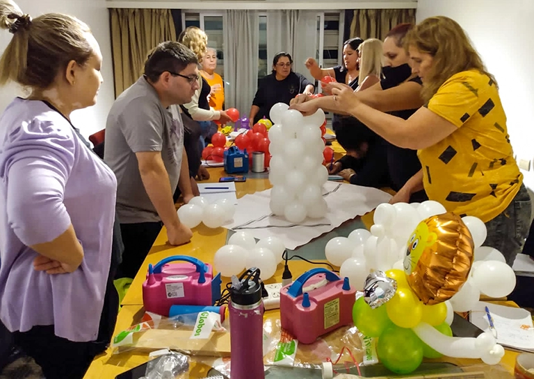 Alumnos realizando el número 1 sobre una mesa en globos color blanco