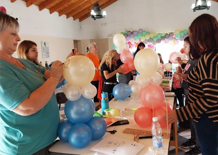 Alumnos realizando flores de globos mientras escuchan a la instructora.