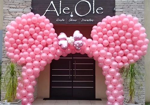 Arco orejas de Minnie Mouse, color rosa, decorando una puerta doble color marrón.